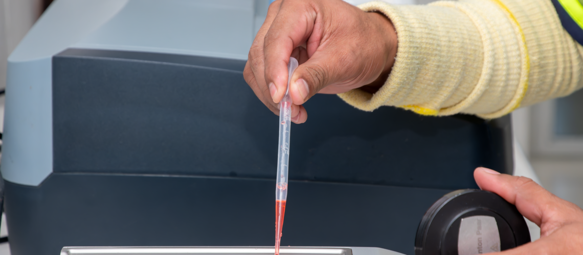 Close-up of a laboratory technician using a pipette for precise measurement in a modern lab.