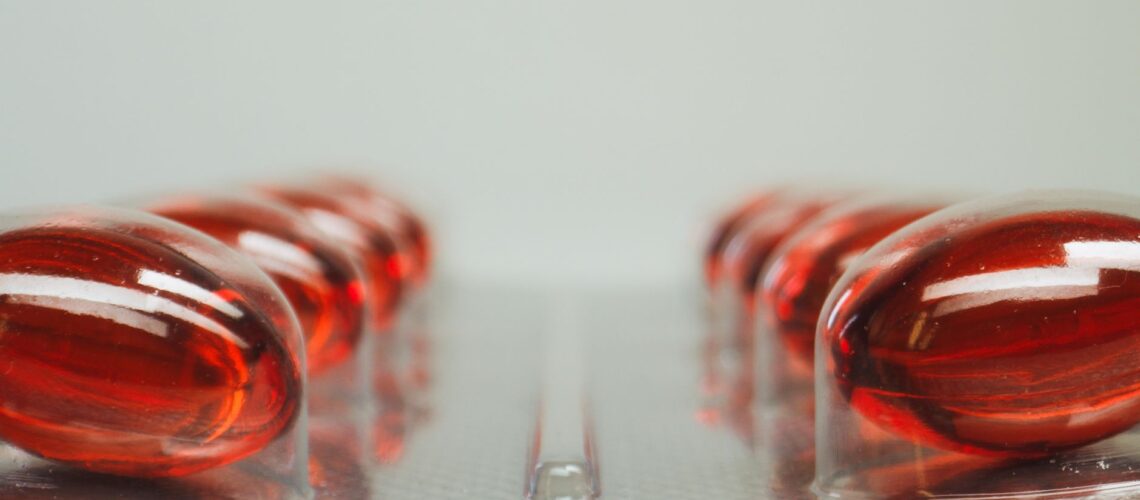 Macro shot of red capsules in a blister pack with selective focus on medicinal pills.