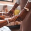 A close-up of two people holding hands, symbolizing support and togetherness.