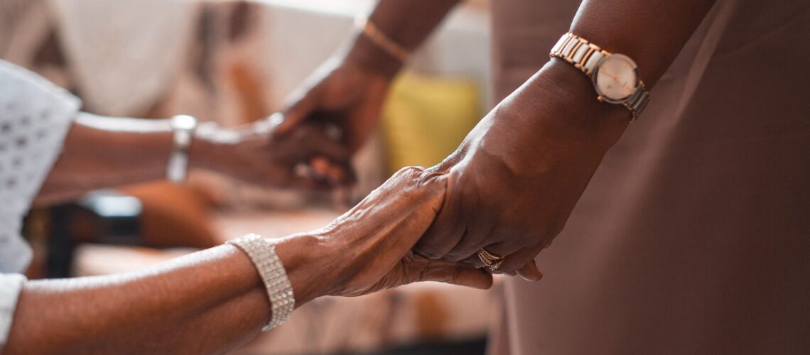 A close-up of two people holding hands, symbolizing support and togetherness.