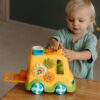 Adorable toddler engaged with a vibrant educational toy, promoting fun learning indoors.