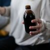 Close view of a person holding an amber medicine bottle, signifying health care and treatment.