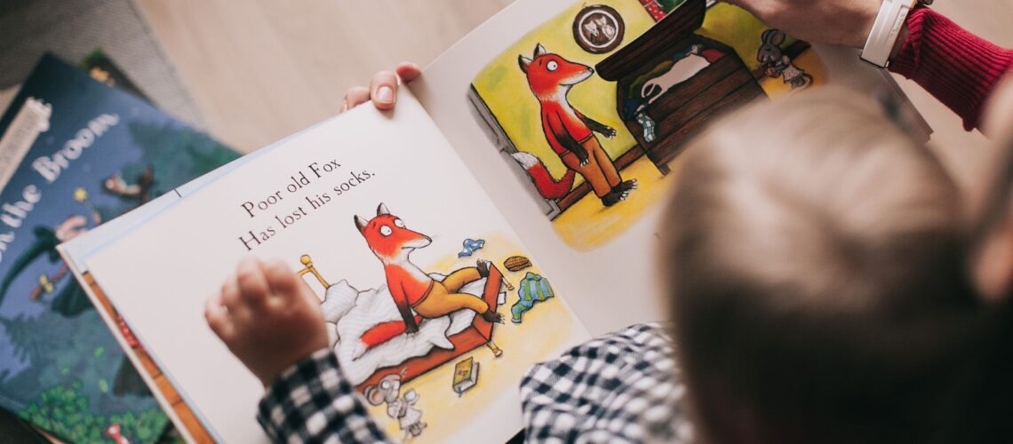 A child and adult reading an illustrated storybook together in a cozy setting.
