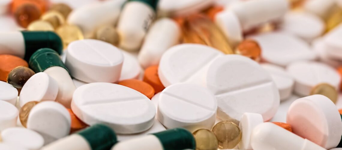 Close-up of various pills and capsules in different colors and sizes, ideal for healthcare-related content.