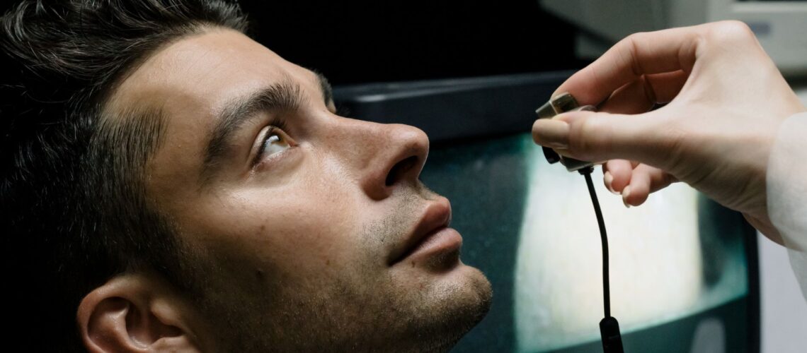 Close-up of a man in a lab setting looking up during an eye examination for medical analysis.