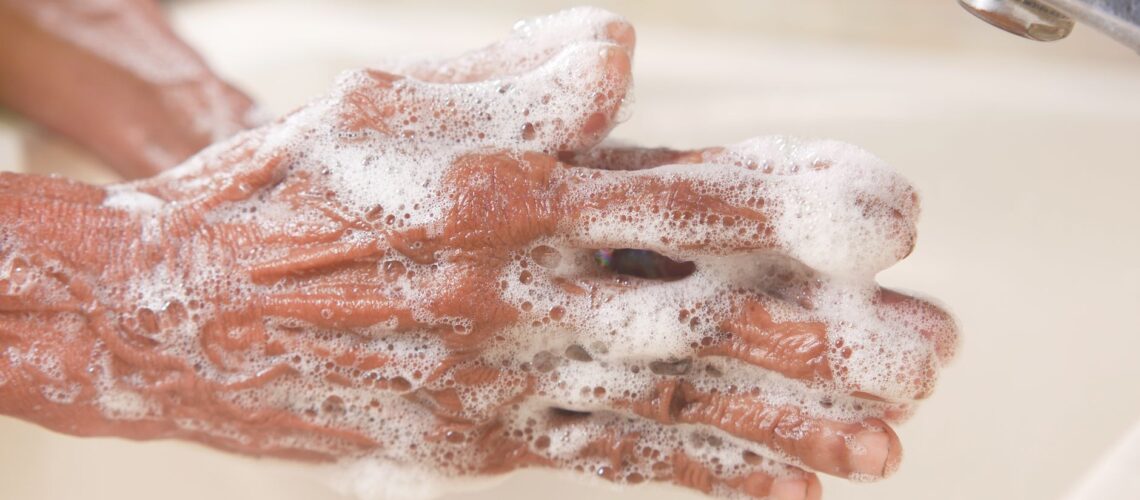 A detailed shot of hands covered in soap lather, highlighting hygiene and cleanliness.