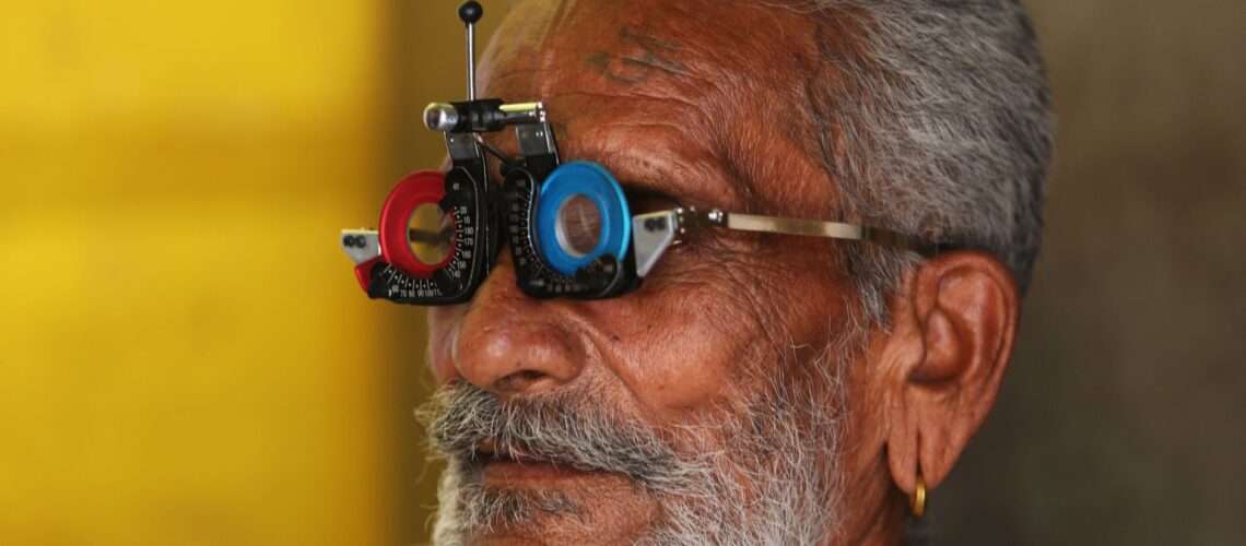 Close-up of a senior man's facial features during an eye examination using specialized equipment.
