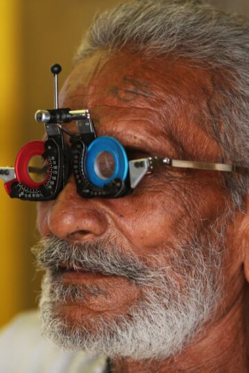 Close-up of a senior man's facial features during an eye examination using specialized equipment.
