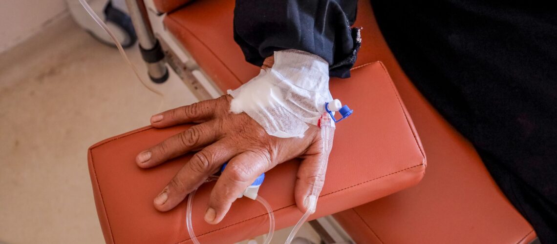 Close-up of a patient's hand receiving chemotherapy treatment in a medical facility.