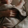 A tender moment of a mother holding her baby wrapped in a blanket, exuding warmth and care.
