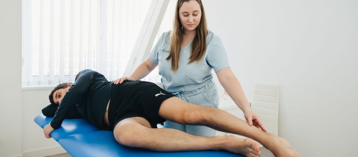 A physiotherapist assists a patient in a rehabilitation session at a Vilnius clinic.