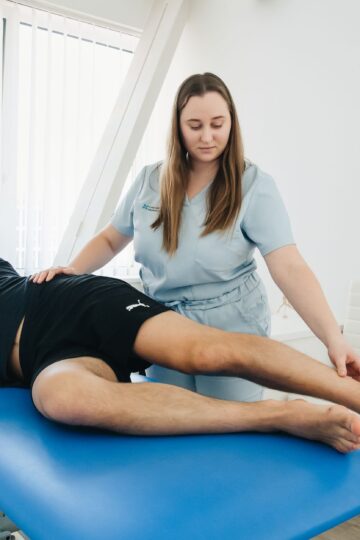 A physiotherapist assists a patient in a rehabilitation session at a Vilnius clinic.