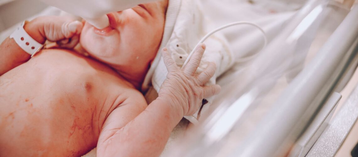 A newborn baby in a hospital setting receiving care with a focus on wellness and health.