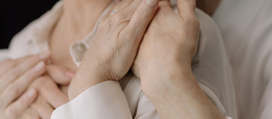 Close-up of elderly women's hands expressing love and connection, symbolizing intimacy and warmth.