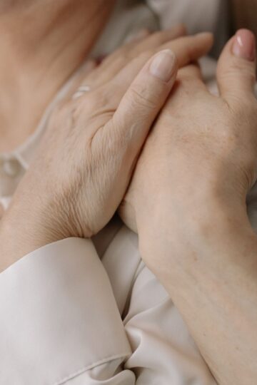 Close-up of elderly women's hands expressing love and connection, symbolizing intimacy and warmth.