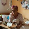 Elderly woman enjoying a meal in a cozy retirement home setting.