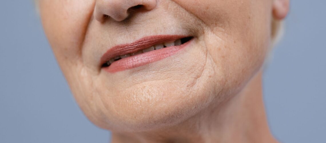 Detailed close-up of an elderly woman's lips and skin, showcasing natural wrinkles.