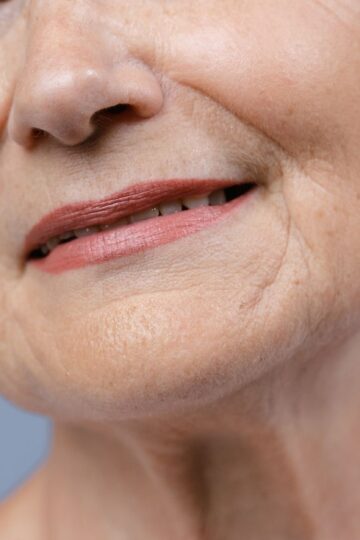Detailed close-up of an elderly woman's lips and skin, showcasing natural wrinkles.
