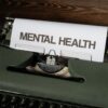 Close-up of a vintage typewriter displaying a mental health message on paper.