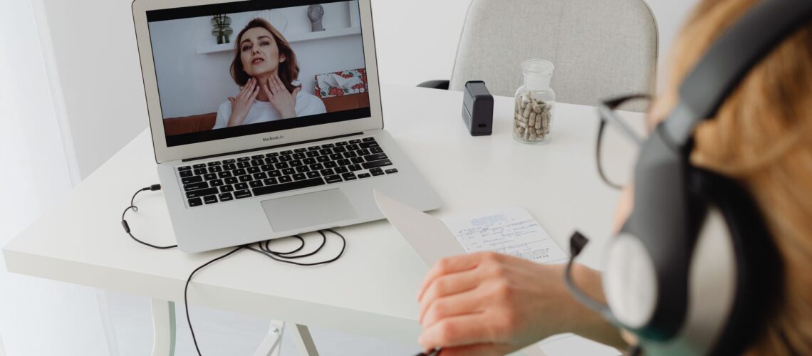 A healthcare professional video conferencing with a patient for an online consultation.