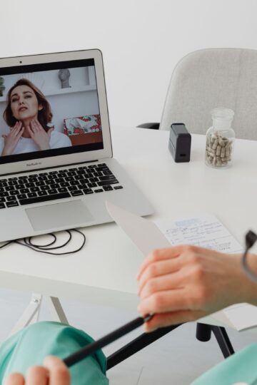 A healthcare professional video conferencing with a patient for an online consultation.