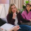 A couple holding hands during a therapy session in an office setting.