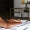 Close-up of acupuncture needles in a hand during treatment, promoting relaxation.