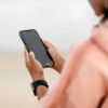 Close-up of a person using a smartphone outdoors, focusing on modern technology.