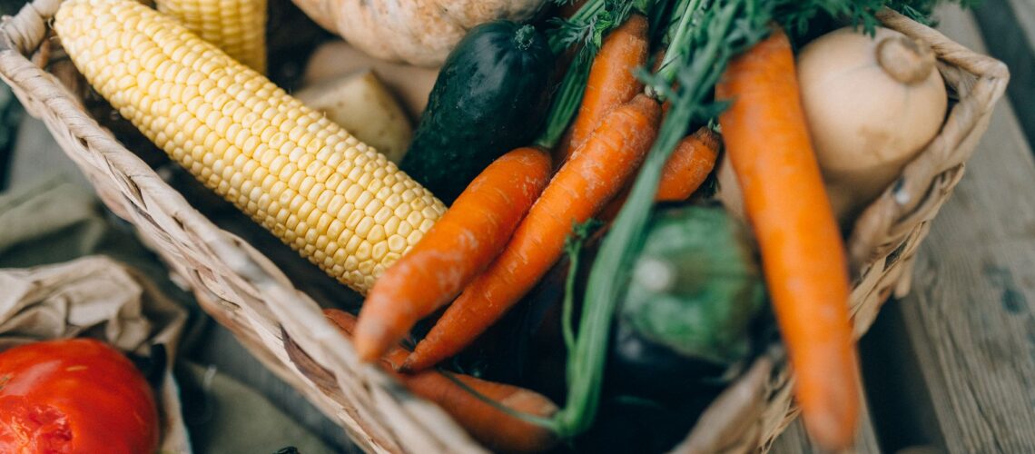 A close-up of fresh organic vegetables in a wicker basket, perfect for healthy eating.