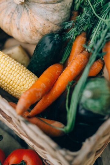 A close-up of fresh organic vegetables in a wicker basket, perfect for healthy eating.