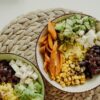 Top view of vegetarian bowls with avocado, corn, beans, and cheese for a delicious meal.