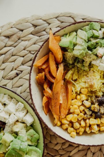 Top view of vegetarian bowls with avocado, corn, beans, and cheese for a delicious meal.