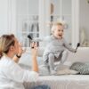 Mother and daughter enjoying a playful moment on the living room sofa.