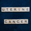 Scrabble tiles spelling 'uterine cancer' on a dark blue background, symbolizing awareness.