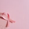 Breast cancer awareness concept with a pink ribbon on a pink October calendar.