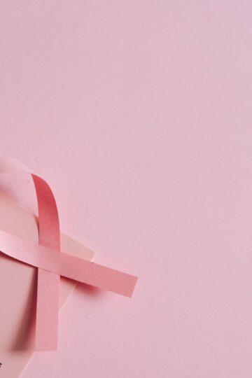 Breast cancer awareness concept with a pink ribbon on a pink October calendar.