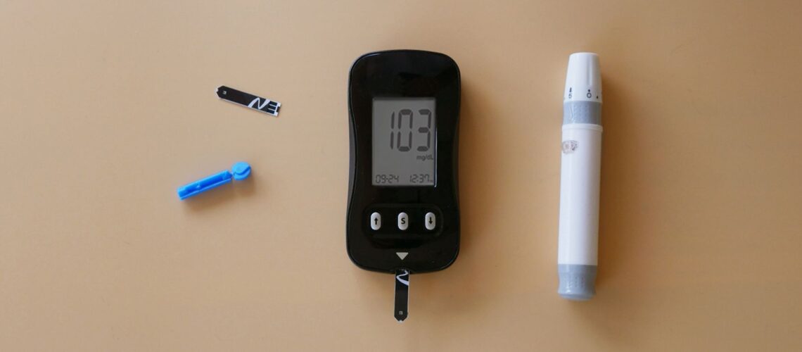 Medical tools for diabetes blood sugar testing on a beige background.