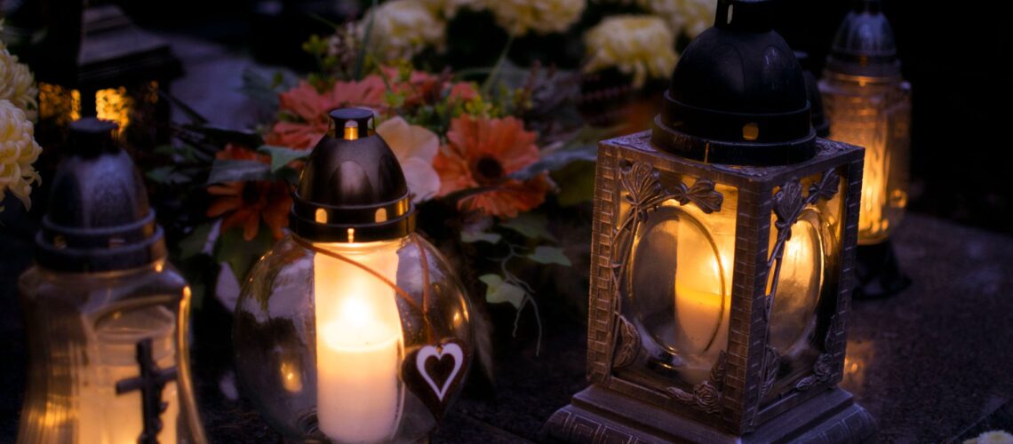 Lanterns with candles illuminate a cemetery on All Saints' Day.