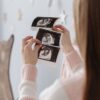 A pregnant woman looks at ultrasound images, showcasing her baby's development. Perfect for healthcare and pregnancy themes.