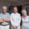 Group portrait of caregivers with senior adults in a home setting.