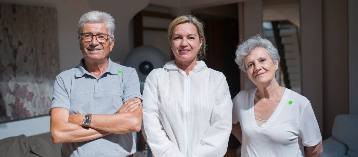 Group portrait of caregivers with senior adults in a home setting.