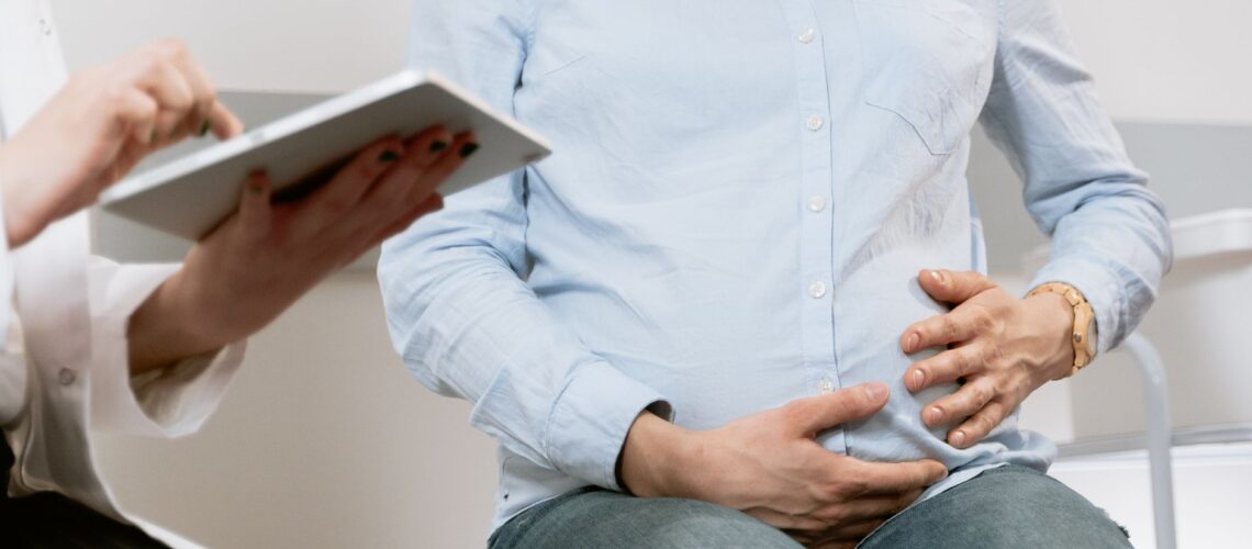 Pregnant woman attending a healthcare consultation, showcasing doctor-patient interaction.