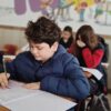 A group of children taking a test with focus and concentration in a classroom setting.