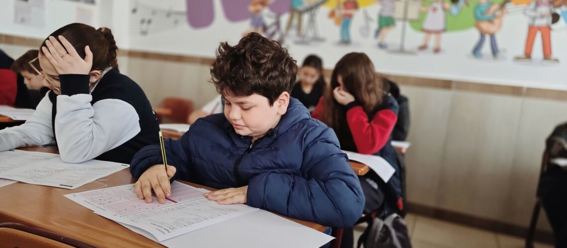 A group of children taking a test with focus and concentration in a classroom setting.