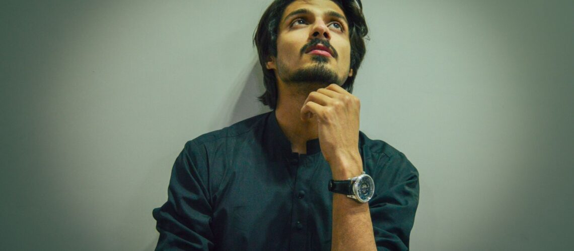 Portrait of a thoughtful man pondering indoors. Cool tone, introspective mood.
