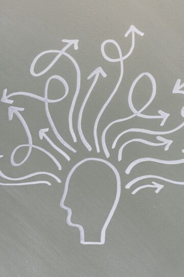 Conceptual chalk drawing illustrating mental health challenges with arrows representing thoughts.