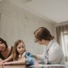 Mother and daughter consult with doctor about child vaccination in a medical office.