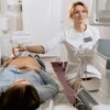 A pregnant woman receiving an ultrasound exam conducted by a healthcare professional in a medical clinic.