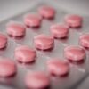 Pink tablets in a blister pack, emphasizing healthcare and medication concepts.