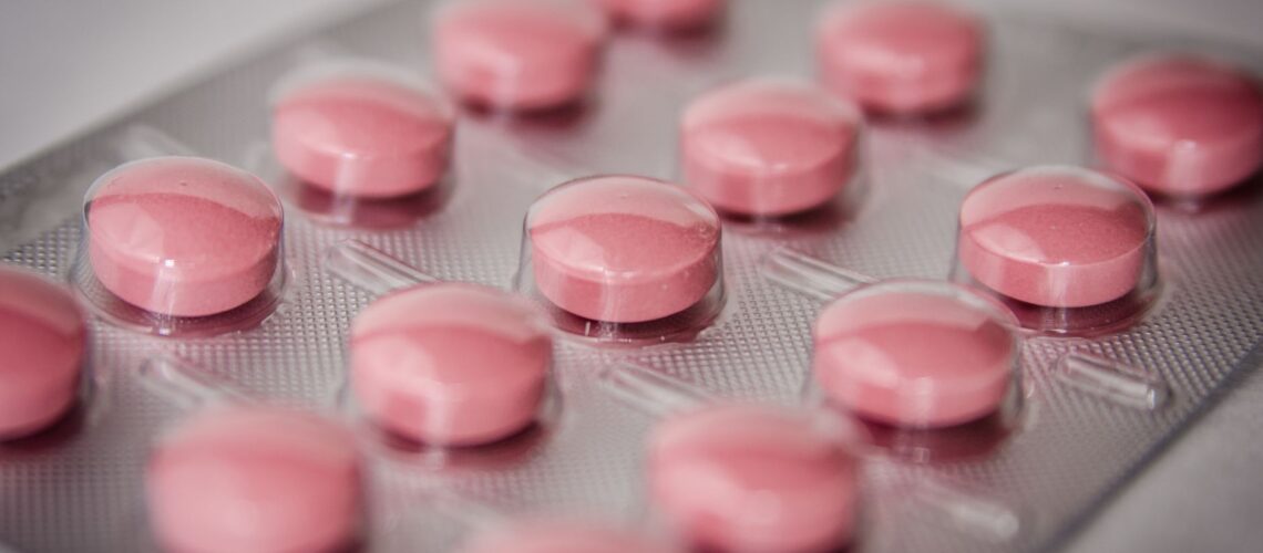 Pink tablets in a blister pack, emphasizing healthcare and medication concepts.